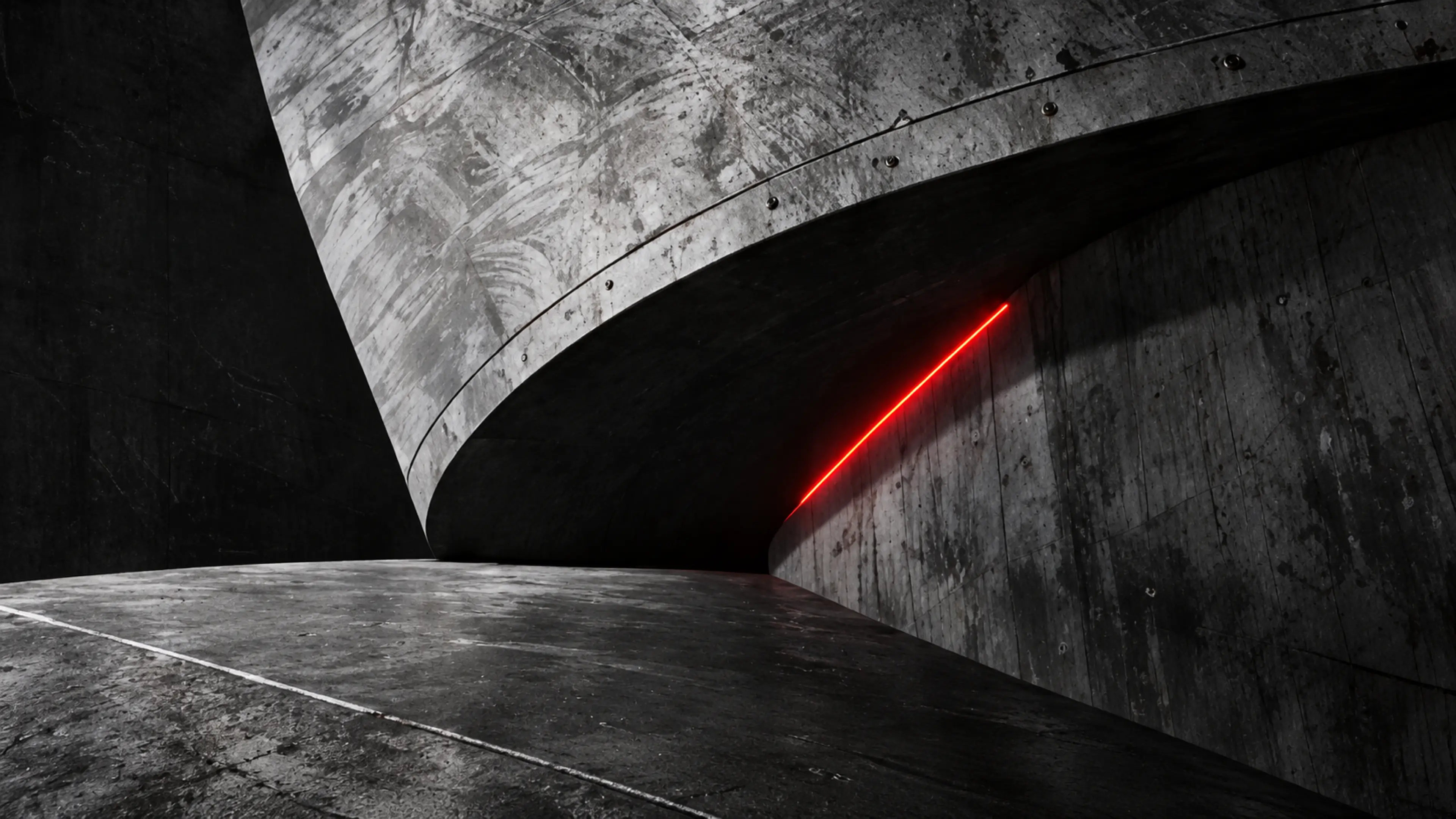 Une courbe de béton monumentale traversée d’un trait rouge.